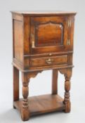 A PERIOD STYLE OAK CUPBOARD ON STAND, PROBABLY BY TITCHMARSH AND GOODWIN