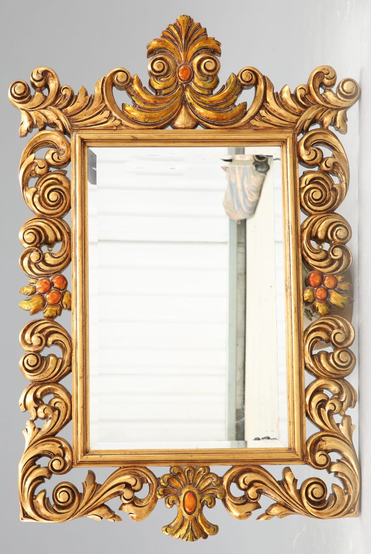 A LARGE BAROQUE STYLE GILT COMPOSITION MIRROR