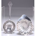 A SILVER TEA STRAINER AND SHELL FORM BUTTER DISH