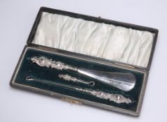 AN EDWARDIAN SILVER-HANDLED BUTTON, GLOVE AND SHOE SET