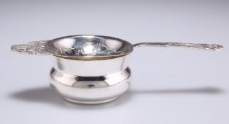 A GEORGE VI SILVER TEA STRAINER ON STAND