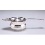 A GEORGE VI SILVER TEA STRAINER ON STAND