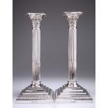 A LARGE PAIR OF EDWARDIAN SILVER COLUMNAR CANDLESTICKS