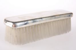 A SILVER-PLATED MOUNTED CLOTHES BRUSH