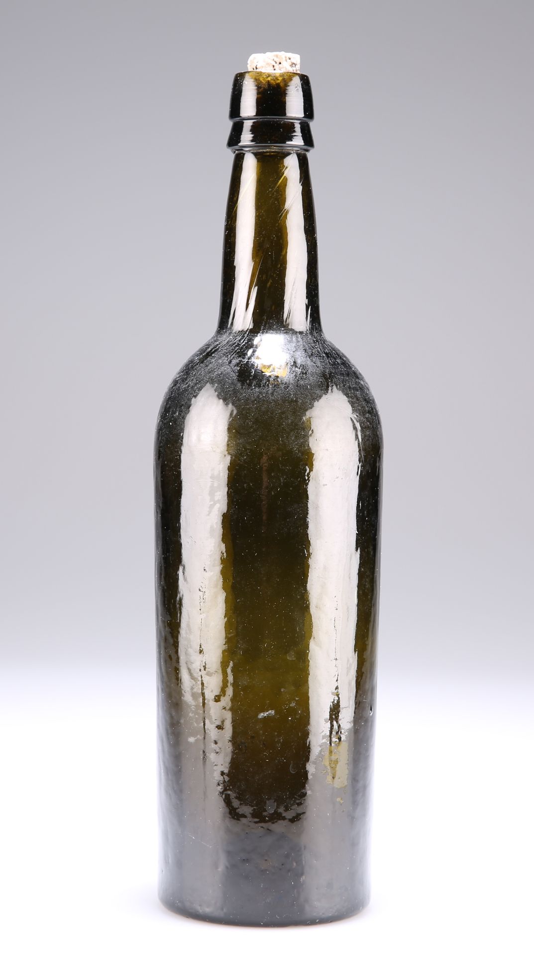 A PLANISHED GREEN GLASS WINE BOTTLE