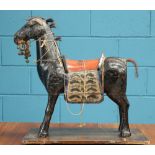 A 19TH CENTURY MIDDLE EASTEN CARVED AND PAINTED MODEL OF A HORSE