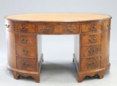 A GEORGE III STYLE LEATHER INSET MAHOGANY OVAL PARTNERS DESK