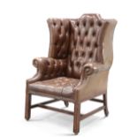 A HANDSOME GEORGE III STYLE DEEP-BUTTONED BROWN LEATHER WING-BACK ARMCHAIR