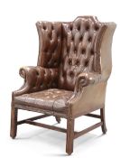 A HANDSOME GEORGE III STYLE DEEP-BUTTONED BROWN LEATHER WING-BACK ARMCHAIR