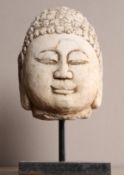 A CHINESE CARVED LIMESTONE HEAD OF BUDDHA