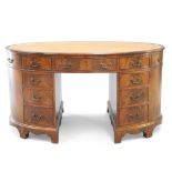 A GEORGE III STYLE LEATHER INSET MAHOGANY OVAL PARTNERS DESK