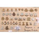 A COLLECTION OF CAP BADGES, COLLAR BADGES AND ARM BADGES