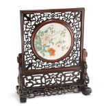 A CHINESE FAMILLE ROSE PORCELAIN AND HARDWOOD TABLE SCREEN