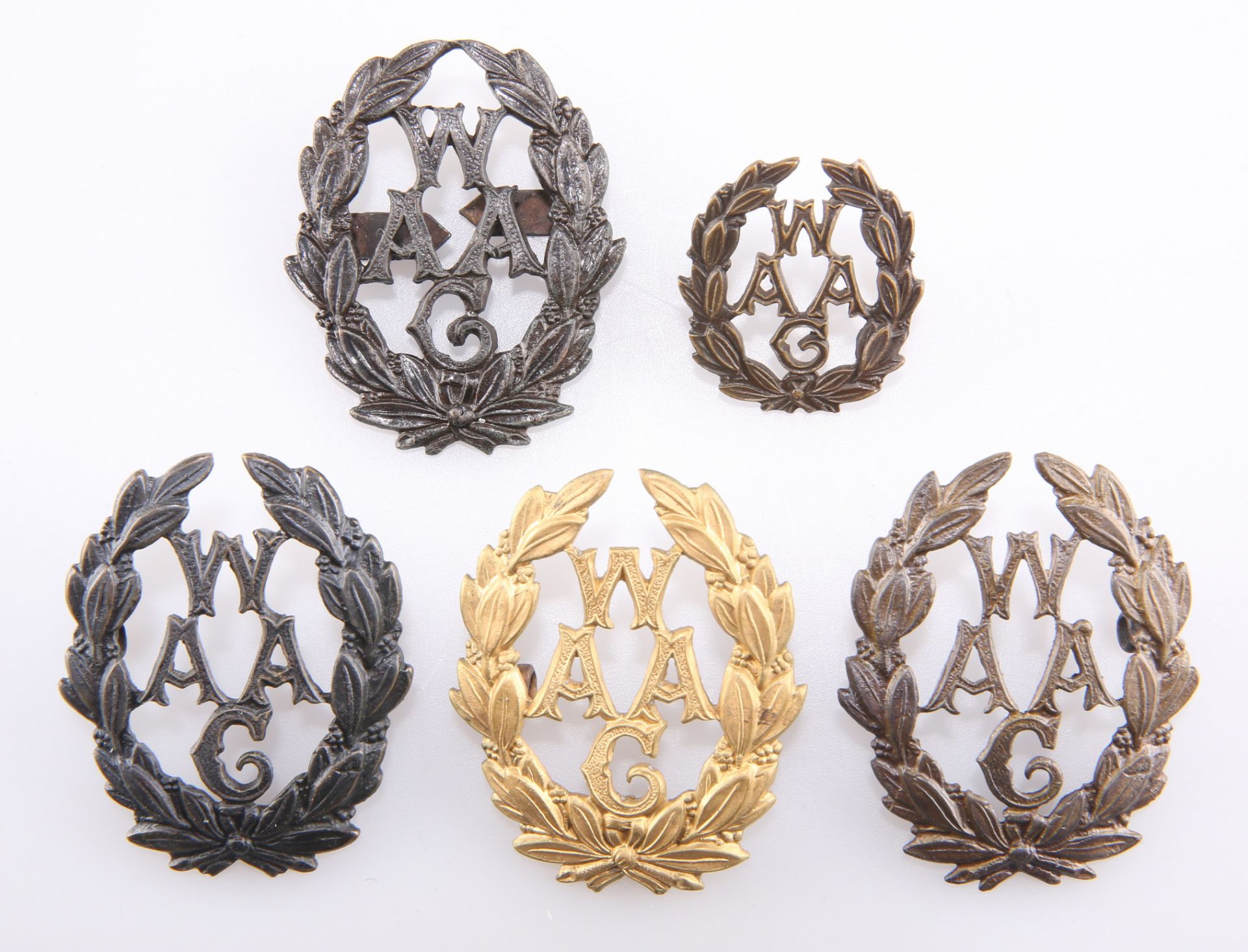 FOUR VARIANT BADGES OF THE WAAF, AND A COLLAR BADGE