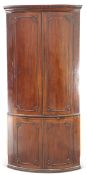 A LARGE GEORGE III MAHOGANY BOW-FRONT DOUBLE CORNER CUPBOARD