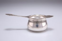 AN ELIZABETH II SILVER TEA STRAINER AND BOWL