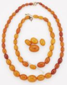 A GRADUATED AMBER BEAD NECKLACE; AND A BROKEN STRAND OF GRADUATED AMBER BEADS
