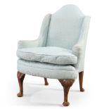 AN EARLY 20TH CENTURY WALNUT AND UPHOLSTERED WING-BACK ARMCHAIR