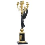 AN EMPIRE-STYLE GILT AND PATINATED METAL FIGURAL CANDELABRUM