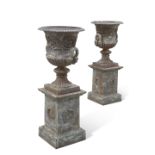 A FINE PAIR OF CAST IRON 'MEDICI' URNS ON STANDS, CIRCA 1900