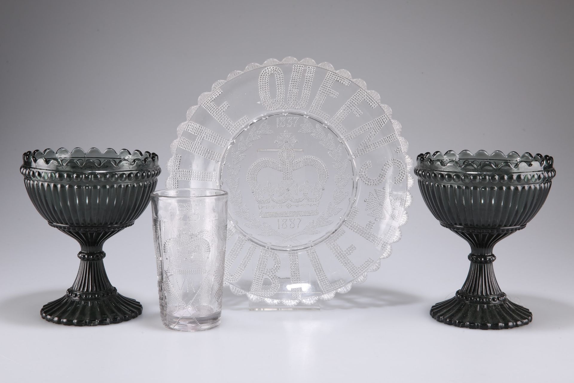 Two smoked glass chalices, together with a commemorative 1837-1887 Victorian pressed glass plate and