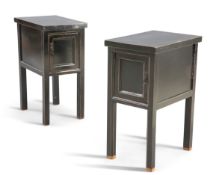 A pair of contemporary black lacquered occasional tables, each fitted with a cupboard door and raise