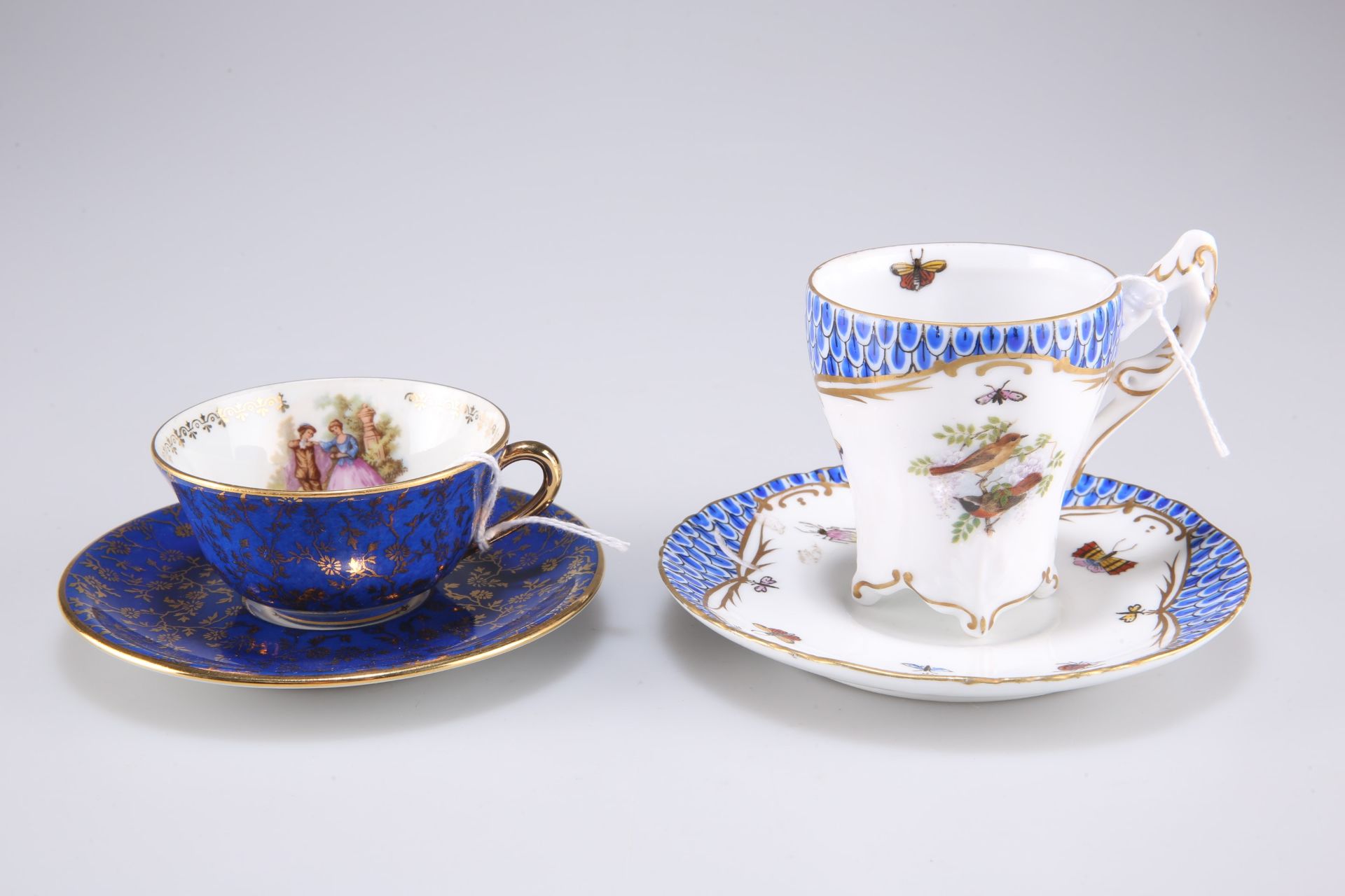 A Continental style cup and saucer decorated with butterflies and birds together with a Limoges