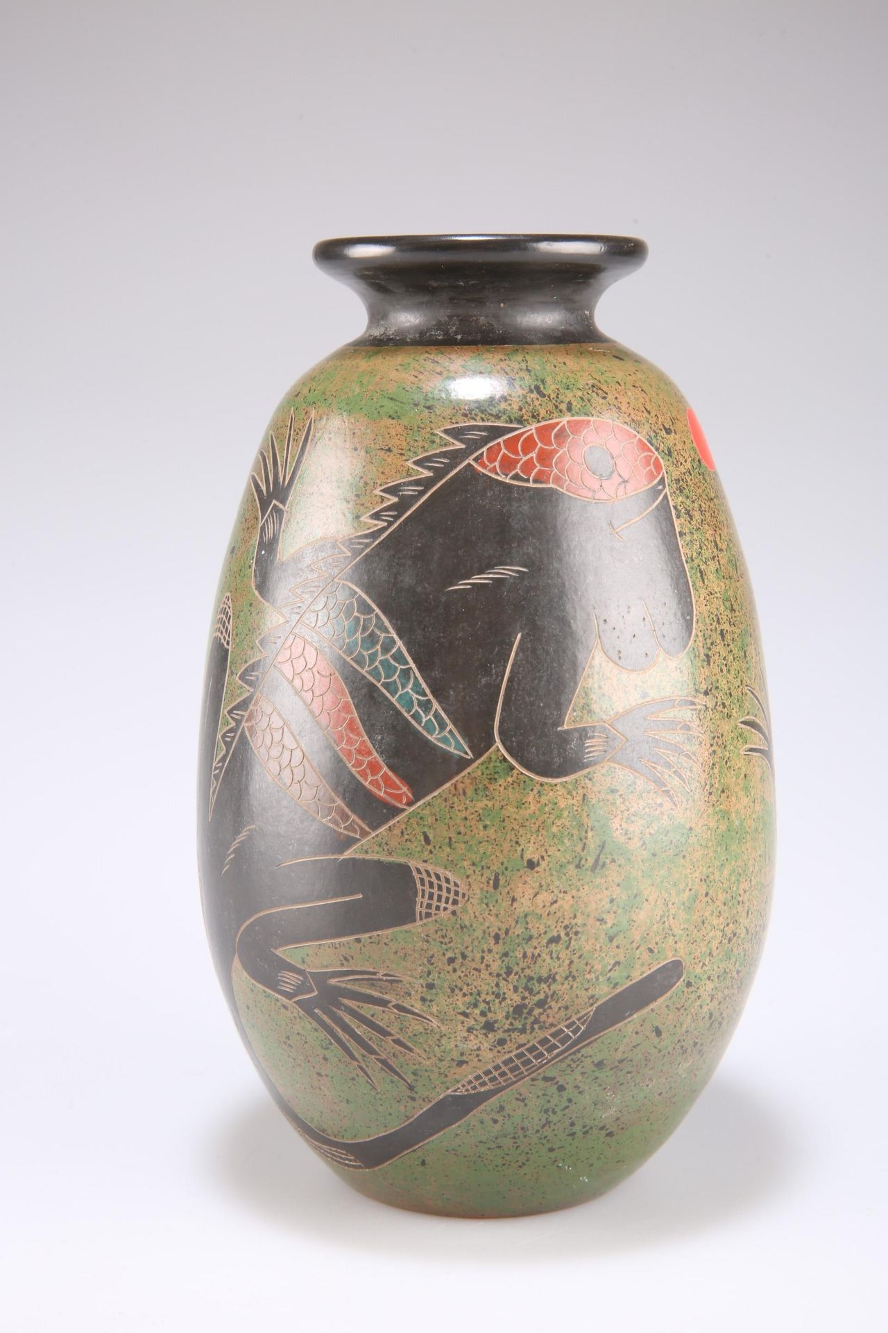 A pottery vase decorated with lizards on a mottled slip glazed ground 20cm high