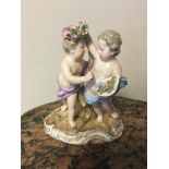 Meissen figure of two children, one holding a wreath over the others head and with a cornucopia