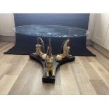 Glass topped coffee table on three winged mythical