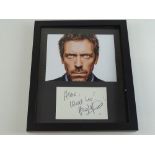 A framed and glazed photograph of HUGH LAURIE in 'House' together with a signed card - PROVENANCE: