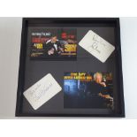 JAMES BOND: A framed and glazed display of 007 flyers with two signature cards: ROGER MOORE and CURD