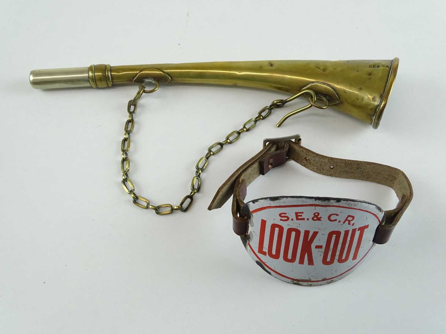 A South Eastern and Chatham Railway 'Look Out' armbadge with strap together with brass warning