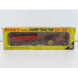 A DINKY 399 Farm Tractor Gift Set containing a Massey Ferguson Tractor and Trailer - G/VG in F/G