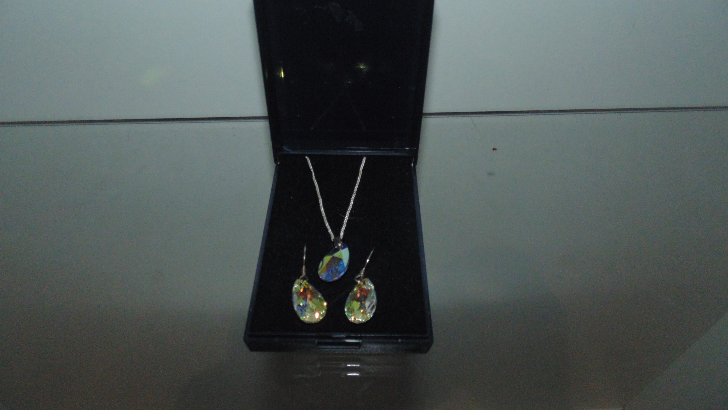 silver opalescent pendant and earrings .