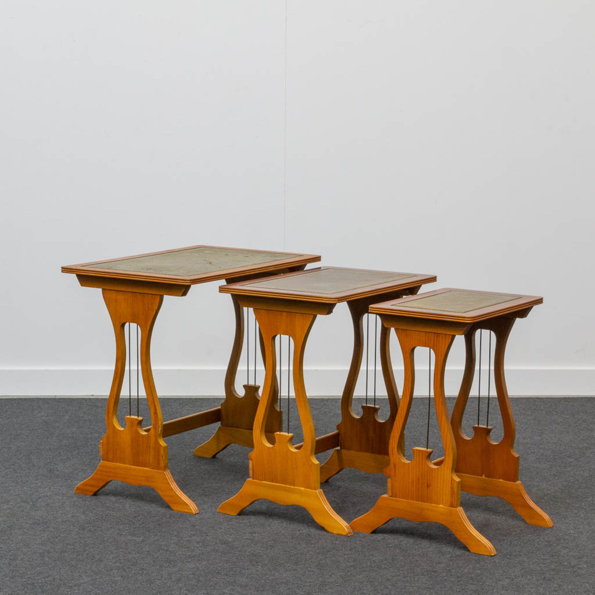 A collection of 3 cigogne tables with leather top.