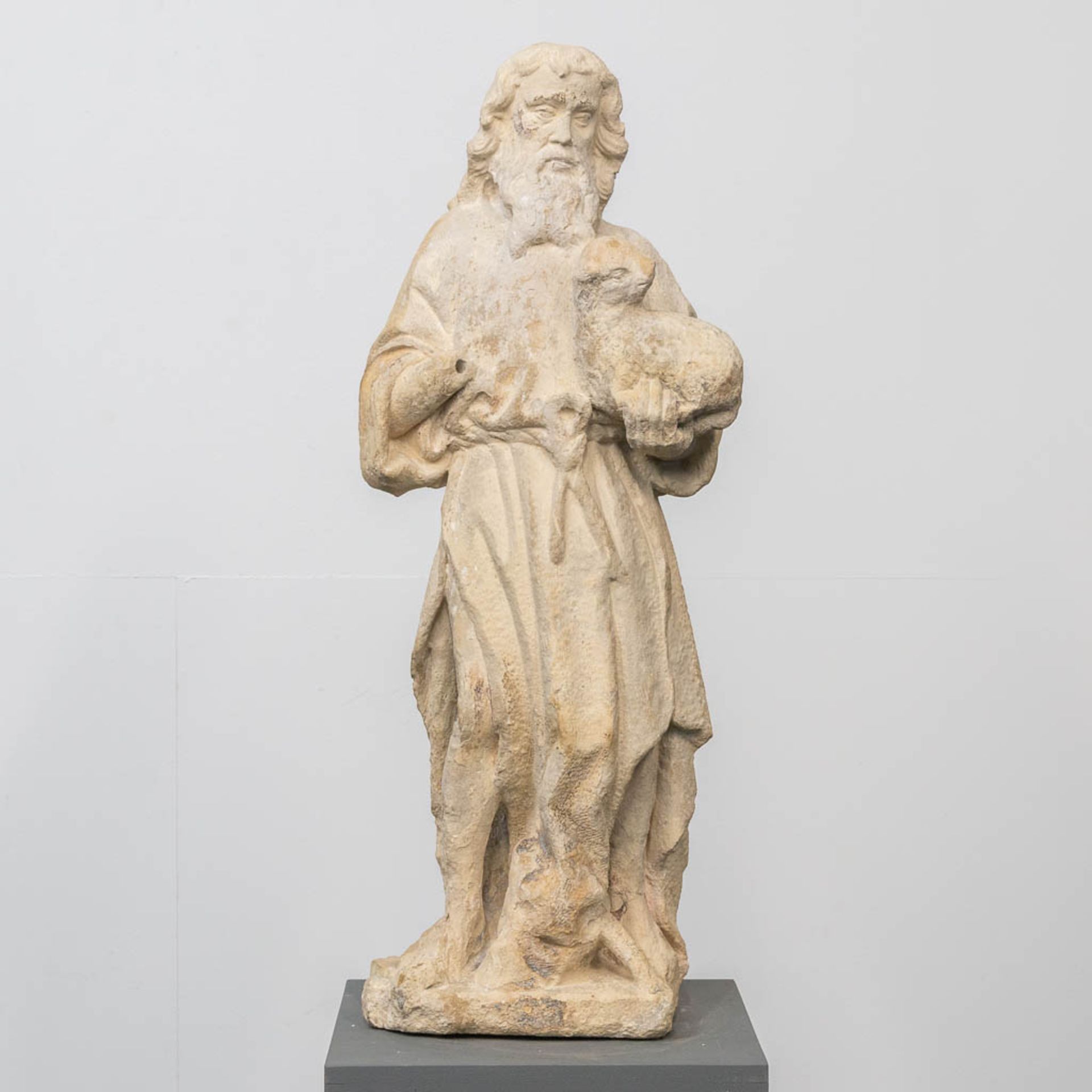 An antique statue of 'John The Baptist' with the lamb, made of sculptured stone.