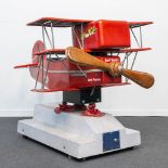 A vintage coin-operated ride, in the shape of a triplane 'Red Baron' airplane with propellor and vid