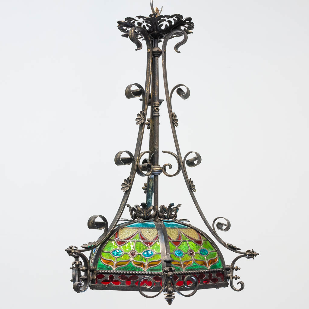 A wrought iron and stained lead glass chandelier.
