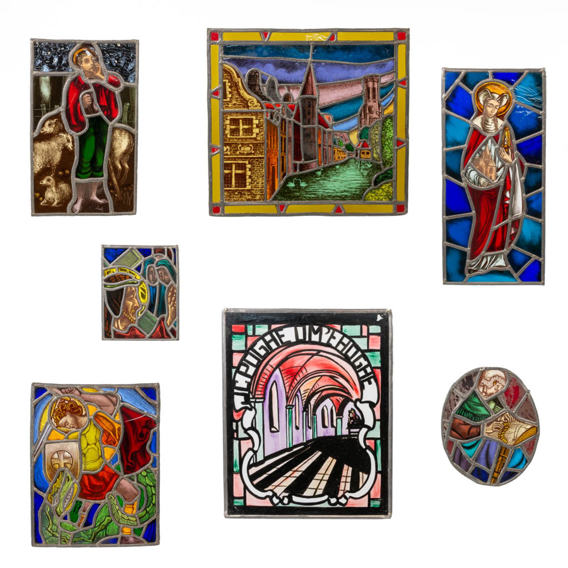 A collection of 7 Stained glass in lead window decorations, with religious decor and a view of Bruge
