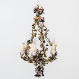 A chandelier made with metal leaves and porcelain flowers