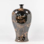 An Asian Vase with black and gold bamboo decor