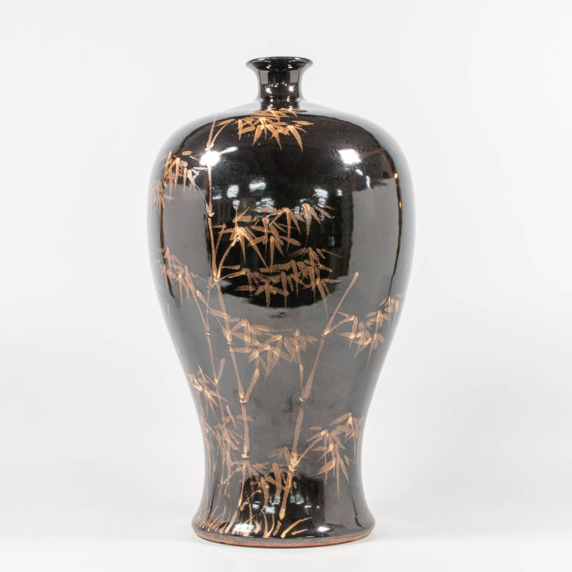 An Asian Vase with black and gold bamboo decor