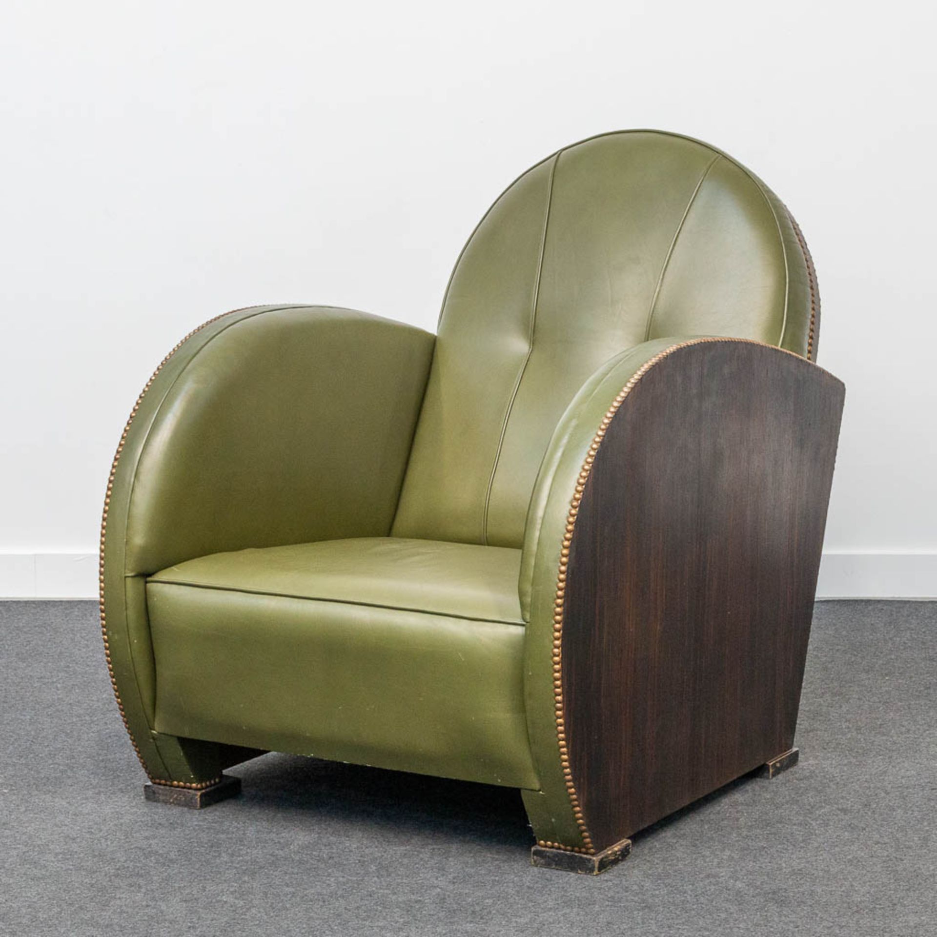 An armchair, upholstered with leather and with wood sides, art deco style.