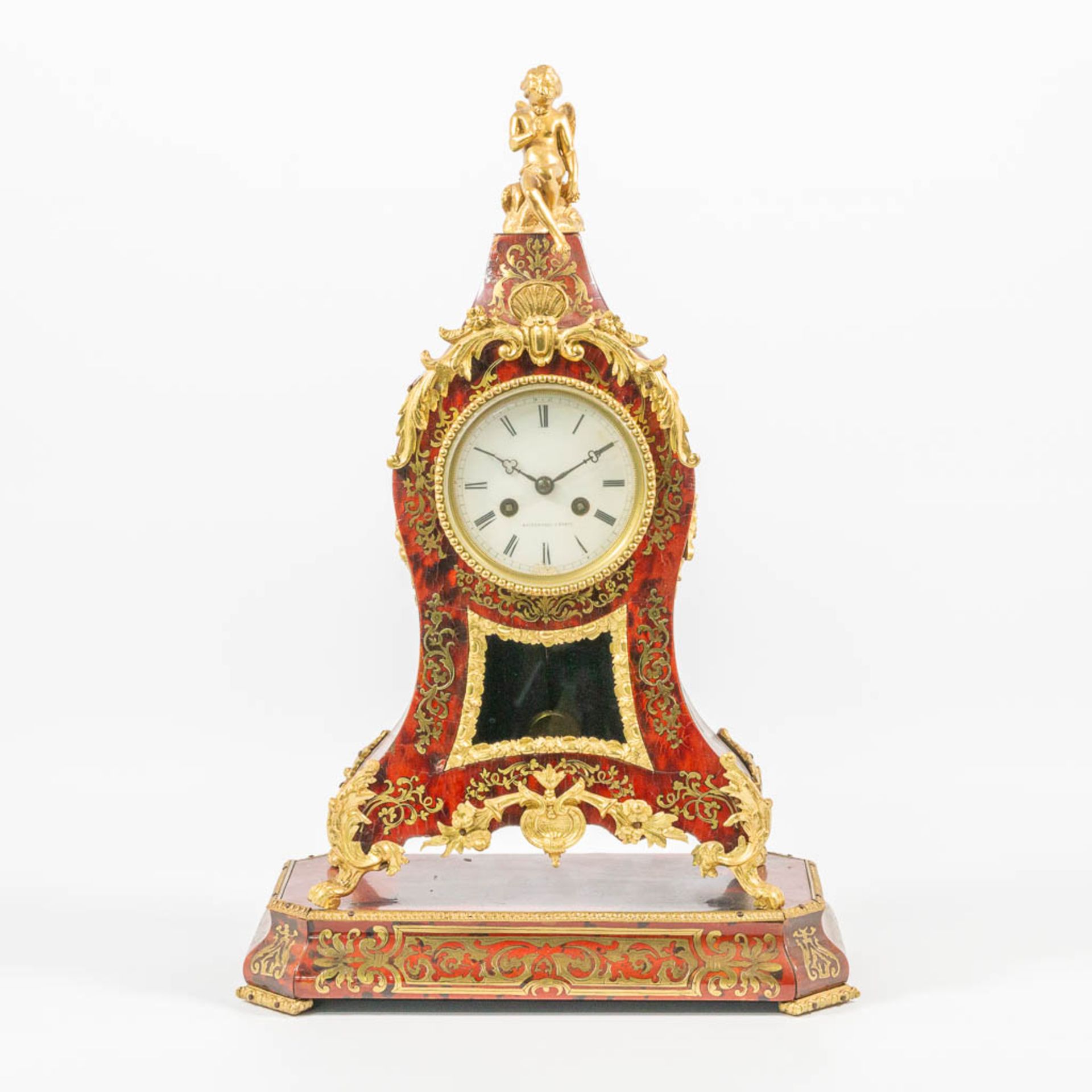 A table clock made of a wood base, with boulle inlay and mounted with bronze, marked Raingo Frères.