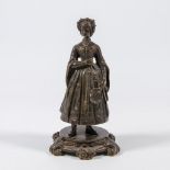 A figural bronze table bell, displayed as a lady with robe.