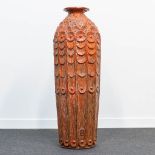 A huge Chamotte clay earthenware vase with floral decor and finished with a red glaze. Maker's mark