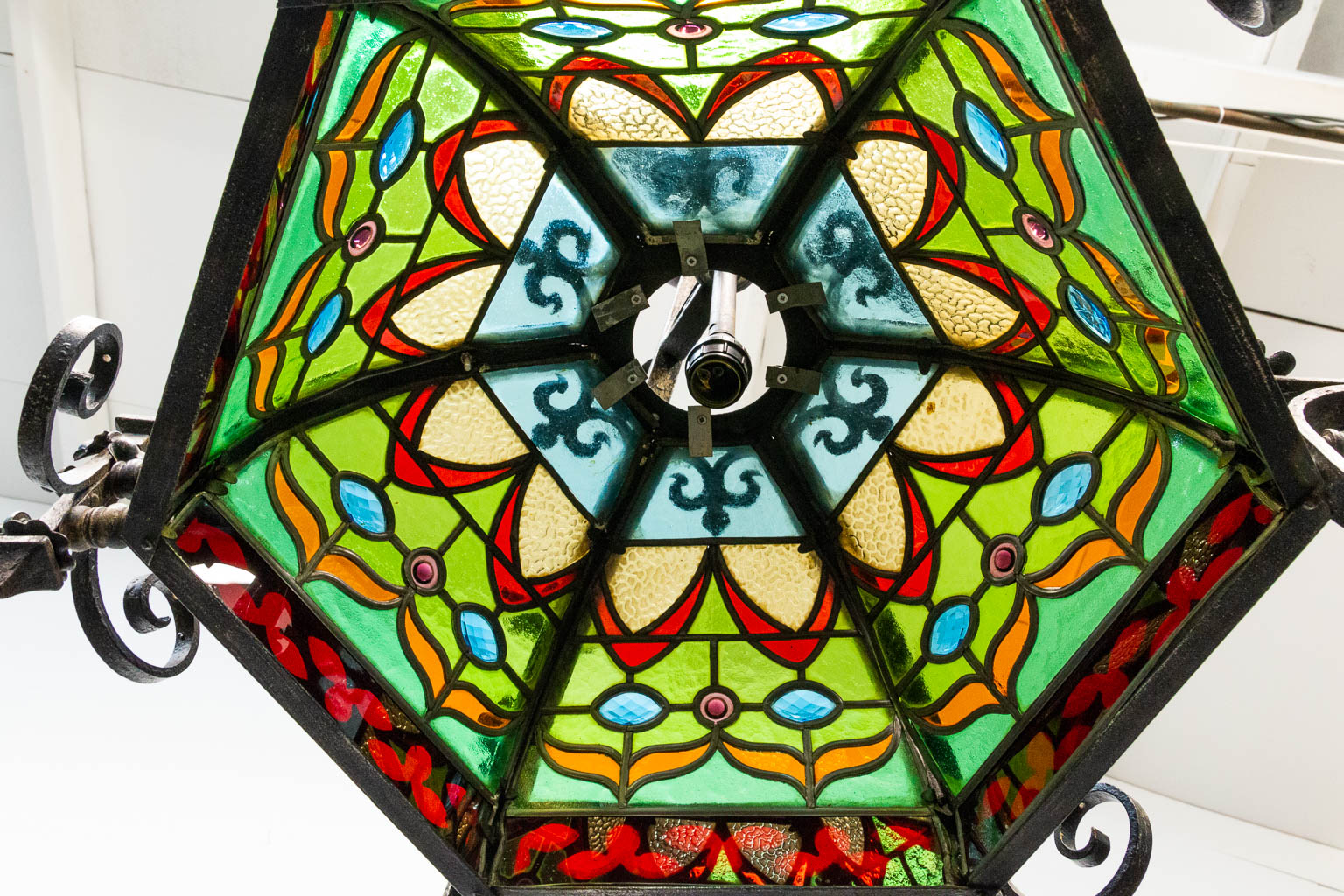 A wrought iron and stained lead glass chandelier. - Image 11 of 12