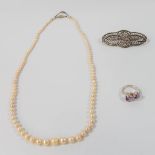 A pearl necklace with 18 karat white gold buckle, combined with a silver ring with purple stones and