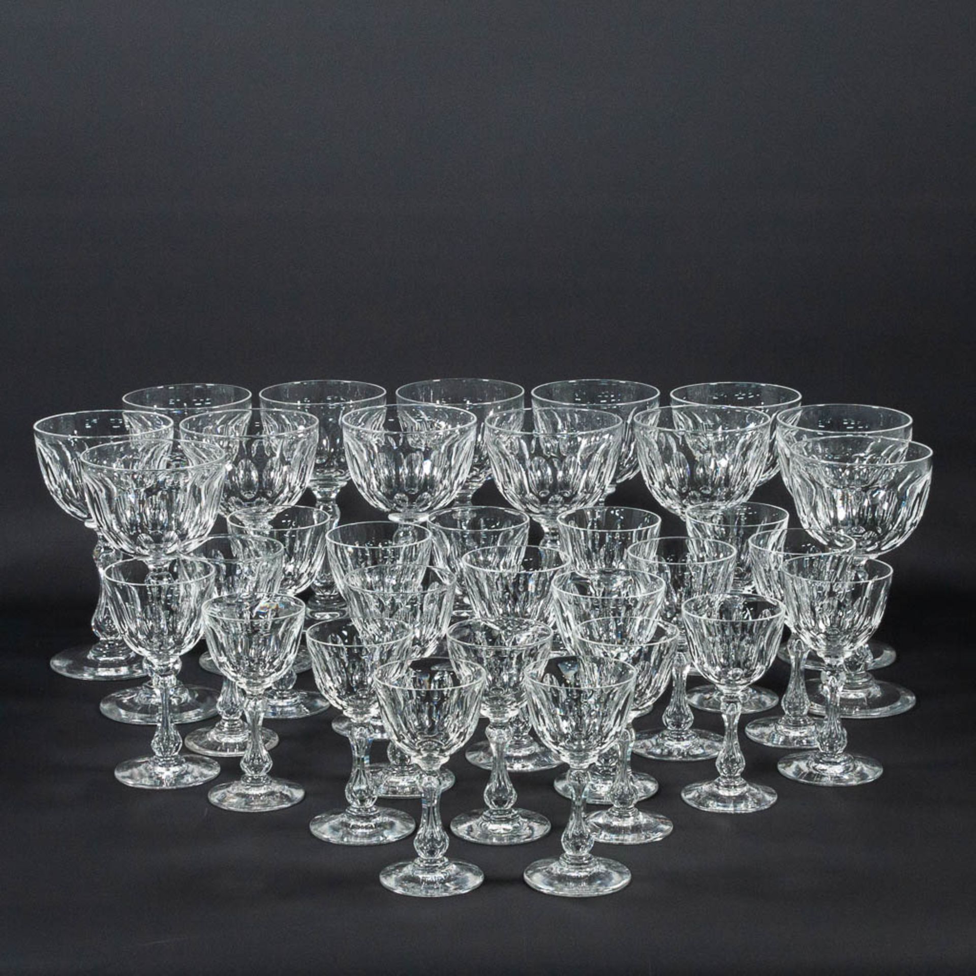 A collection of 34 antique cyrstal glasses with cut sides.